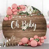 Wooden sign decorated with pink balloons and white flowers displaying ’Oh Baby’ text.